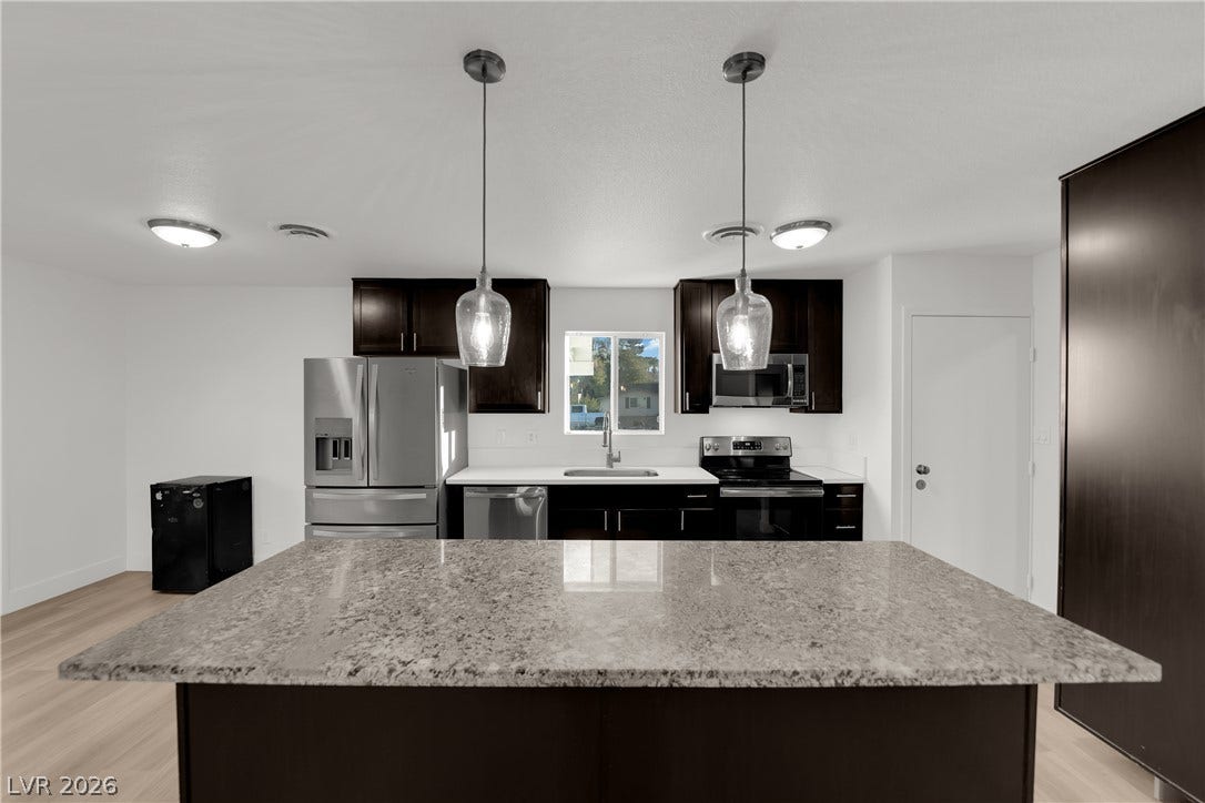 419 Scenic Drive, Henderson, NV 89002 Gleaming stone countertops and dark cabinetry anchor this open culinary space.