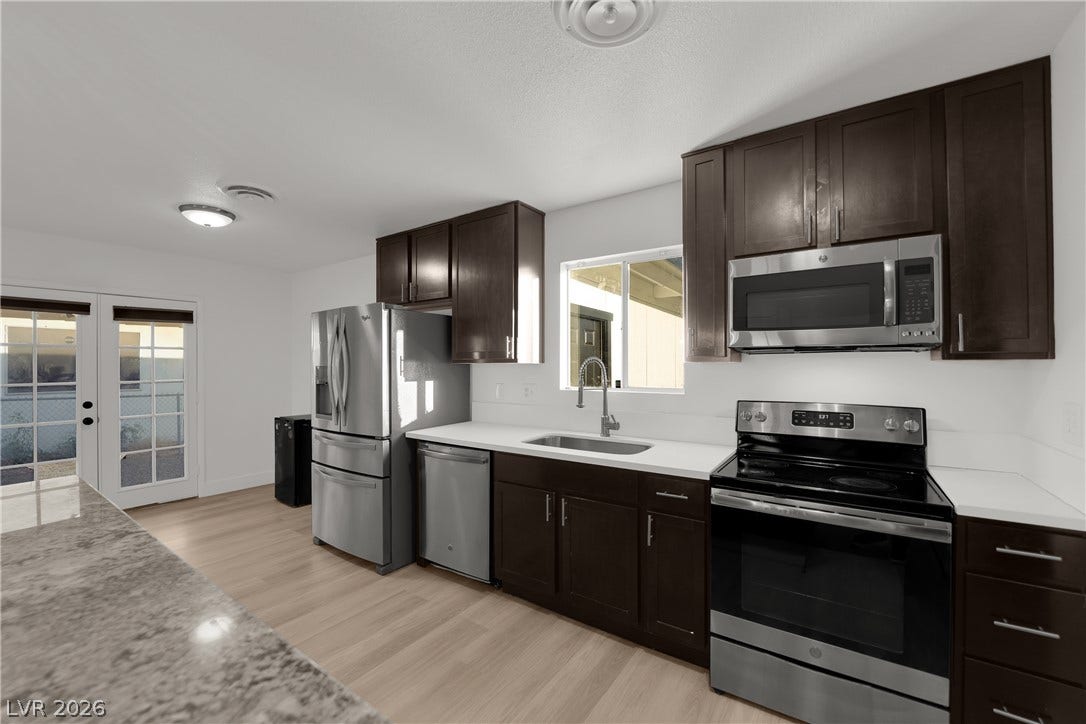 419 Scenic Drive, Henderson, NV 89002 Rich dark cabinetry pairs perfectly with light-toned flooring in this modern culinary workspace.
