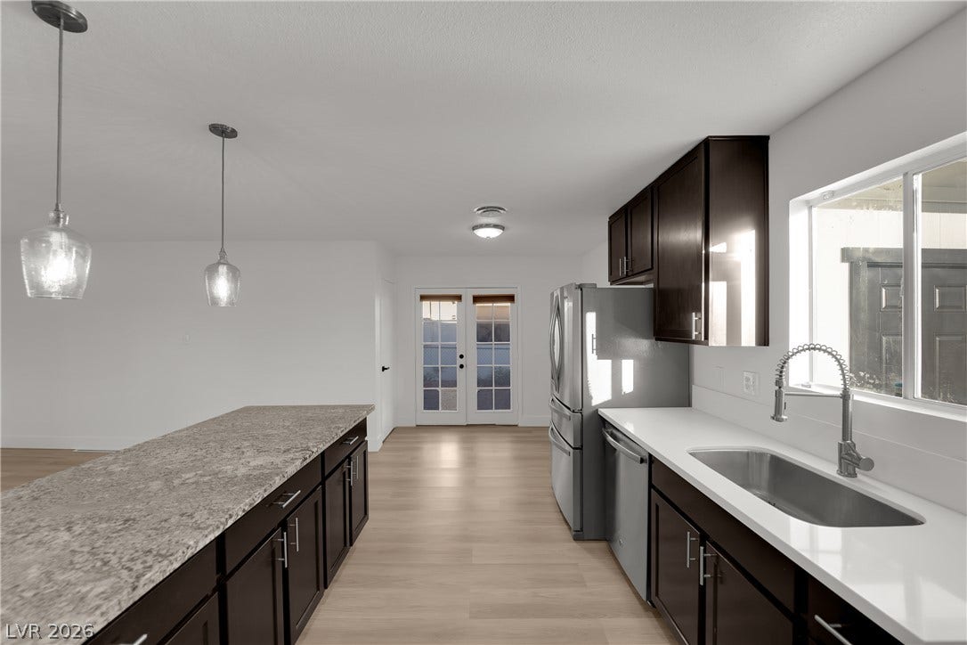 419 Scenic Drive, Henderson, NV 89002 Rich dark cabinetry pairs beautifully with contrasting solid surface countertops in this open kitchen.