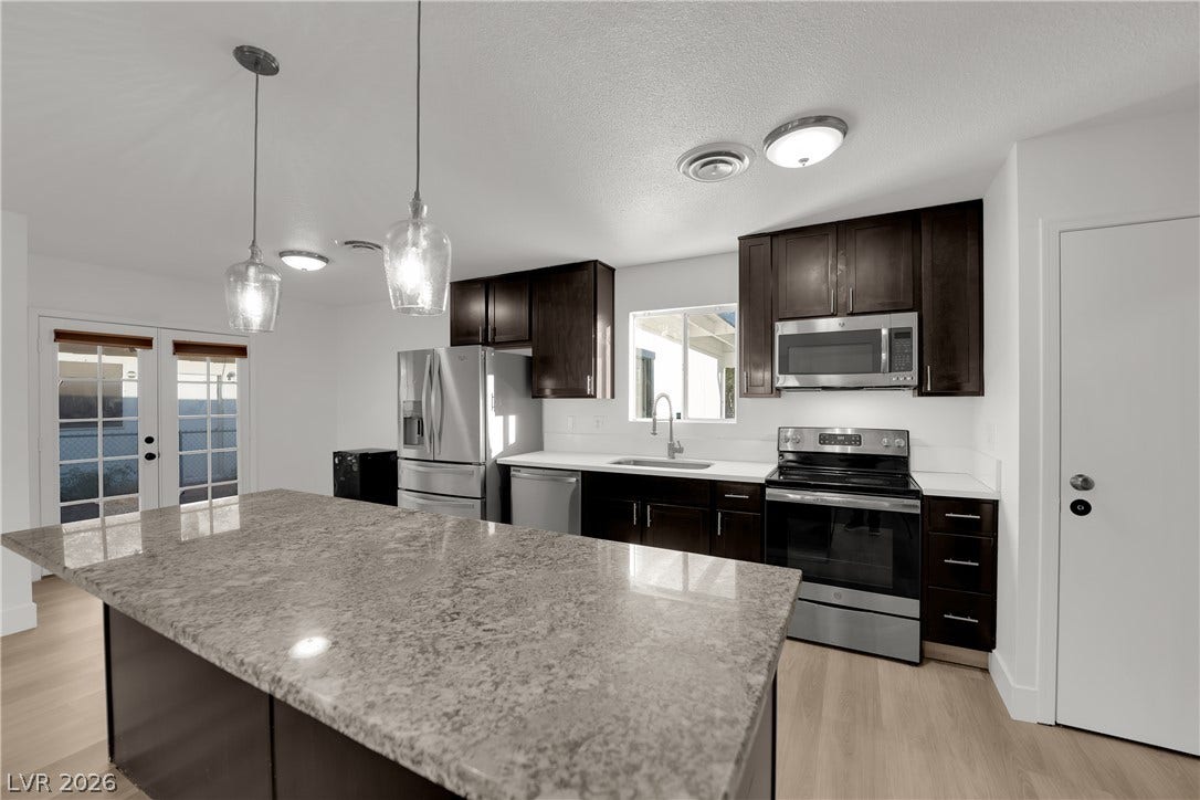 419 Scenic Drive, Henderson, NV 89002 Gleaming stone countertops and dark cabinetry anchor this modern culinary space.
