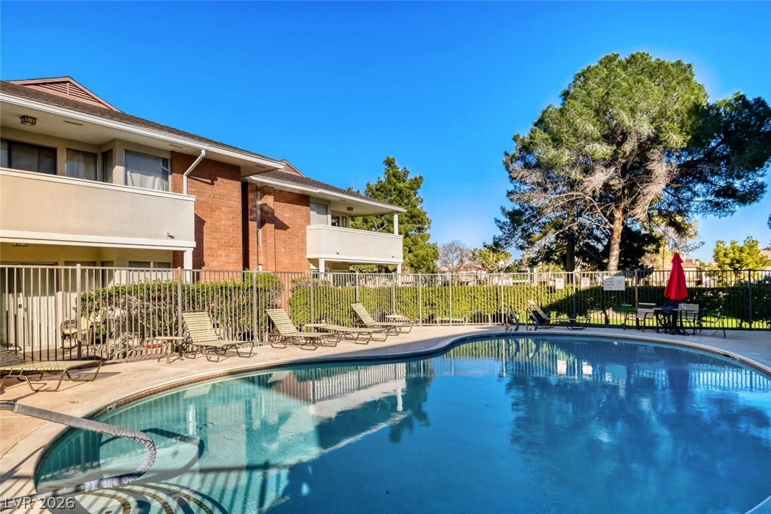769 Oakmont Avenue, #403, Las Vegas, NV 89109 A sparkling community swimming pool sits adjacent to multi-level residential structures under clear blue skies.