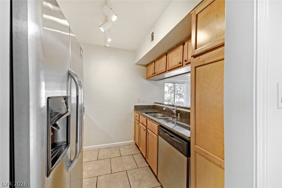 769 Oakmont Avenue, #403, Las Vegas, NV 89109 Gleaming granite countertops pair with natural wood cabinetry in this galley kitchen.