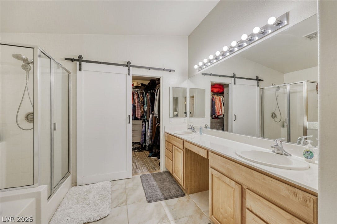 5817 Hawkeye Bell Street, North Las Vegas, NV 89081 A spacious double vanity and a glass-enclosed shower highlight this well-appointed master bathroom.