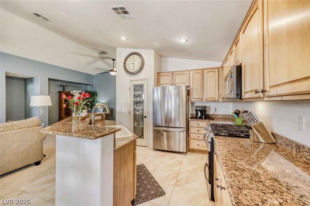 5817 Hawkeye Bell Street, North Las Vegas, NV 89081 Gleaming granite countertops pair beautifully with light wood cabinetry in this airy open-concept layout.
