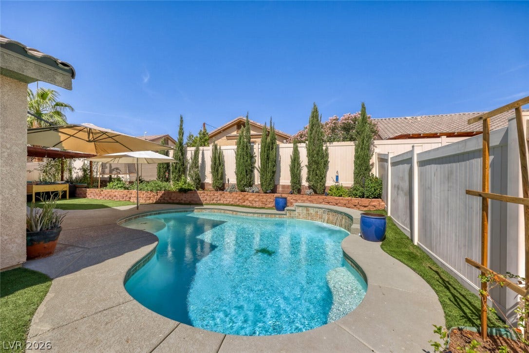 5817 Hawkeye Bell Street, North Las Vegas, NV 89081 A sparkling in-ground pool is framed by concrete decking, professional landscaping, and secure fencing.
