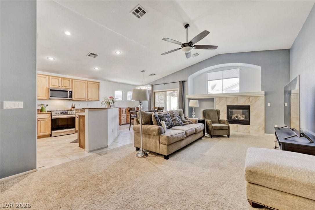 5817 Hawkeye Bell Street, North Las Vegas, NV 89081 Vaulted ceilings and a tiled fireplace anchor this airy, open-concept living area.