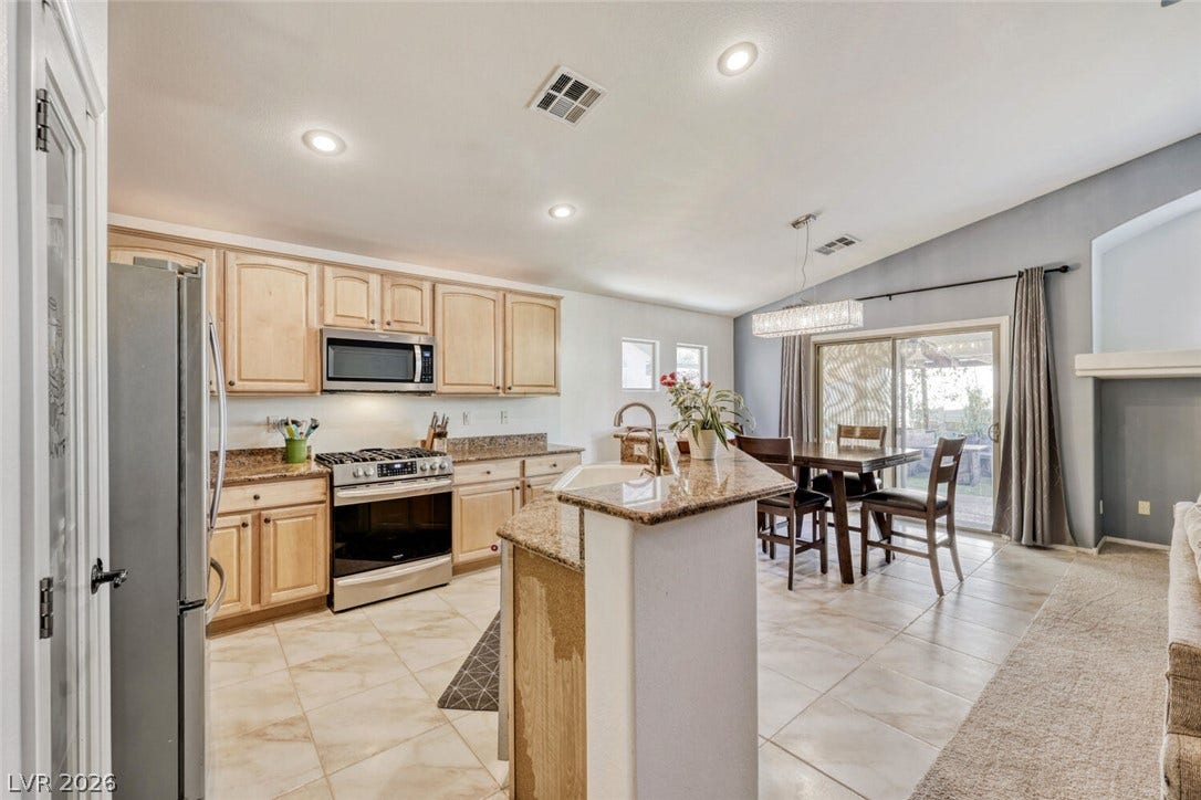 5817 Hawkeye Bell Street, North Las Vegas, NV 89081 Tile flooring and stone countertops anchor this open space seamlessly connecting to the dining area.