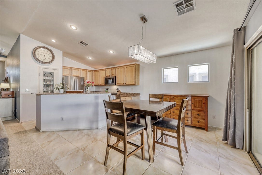 5817 Hawkeye Bell Street, North Las Vegas, NV 89081 Polished tile flooring and an open layout seamlessly connect the dining space and kitchen.