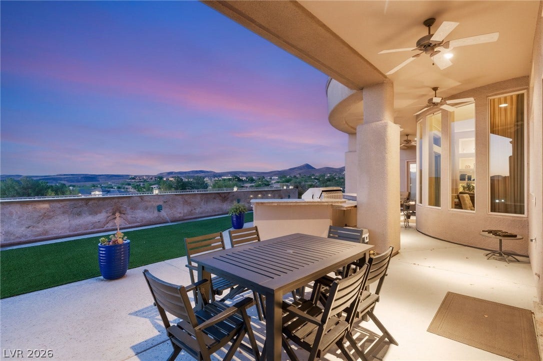 6 Brookridge Drive, Henderson, NV 89052 An expansive covered patio showcases sweeping mountain vistas under dramatic sunset skies.