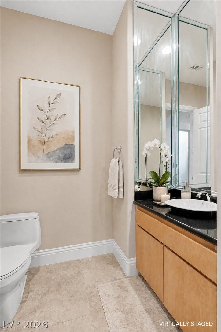 6 Brookridge Drive, Henderson, NV 89052 Smooth tile flooring, crown molding, and stone counters elevate this stylish powder room.