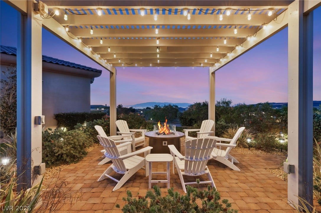 6 Brookridge Drive, Henderson, NV 89052 A stone paver patio sits under a lighted pergola, framing distant mountain and valley views.