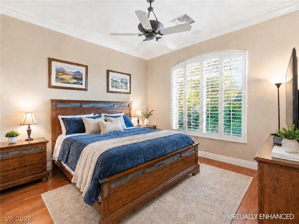 6 Brookridge Drive, Henderson, NV 89052 Polished wood floors and elegant crown molding elevate this serene primary bedroom retreat.