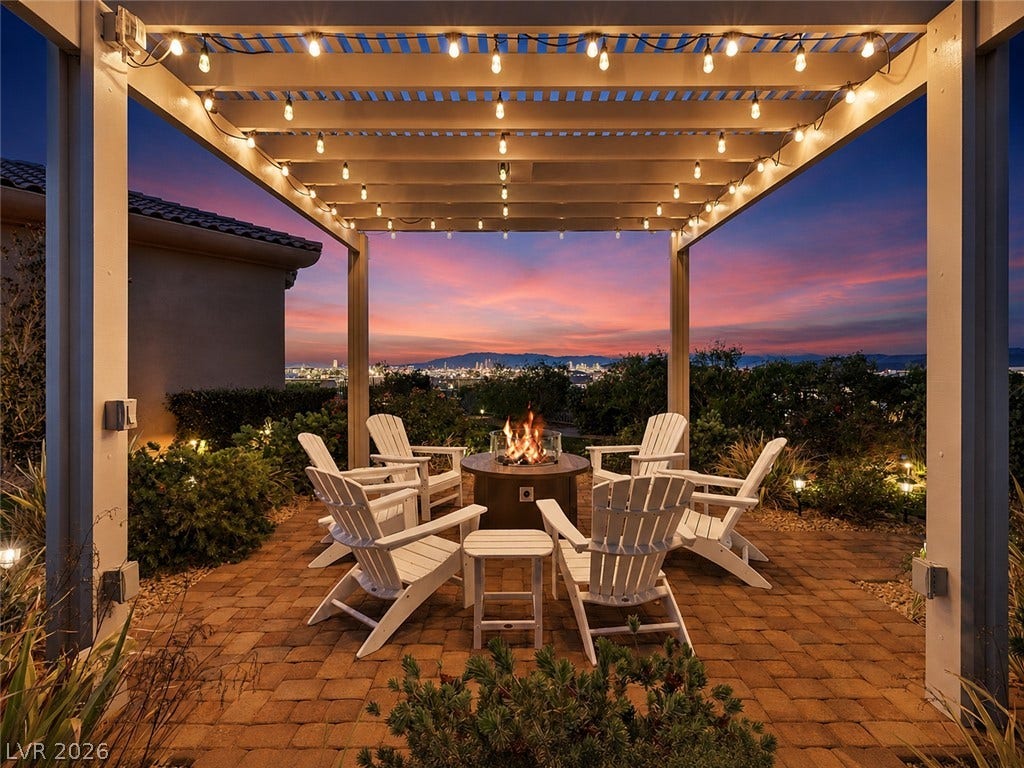 6 Brookridge Drive, Henderson, NV 89052 An inviting stone paver patio sits under a pergola, framing sweeping city light views.