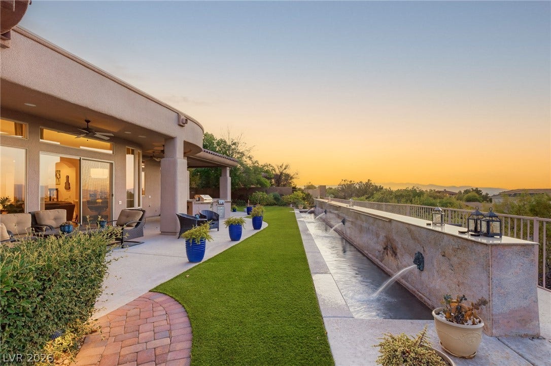 6 Brookridge Drive, Henderson, NV 89052 An elegant outdoor terrace features a custom water channel alongside a manicured lawn.