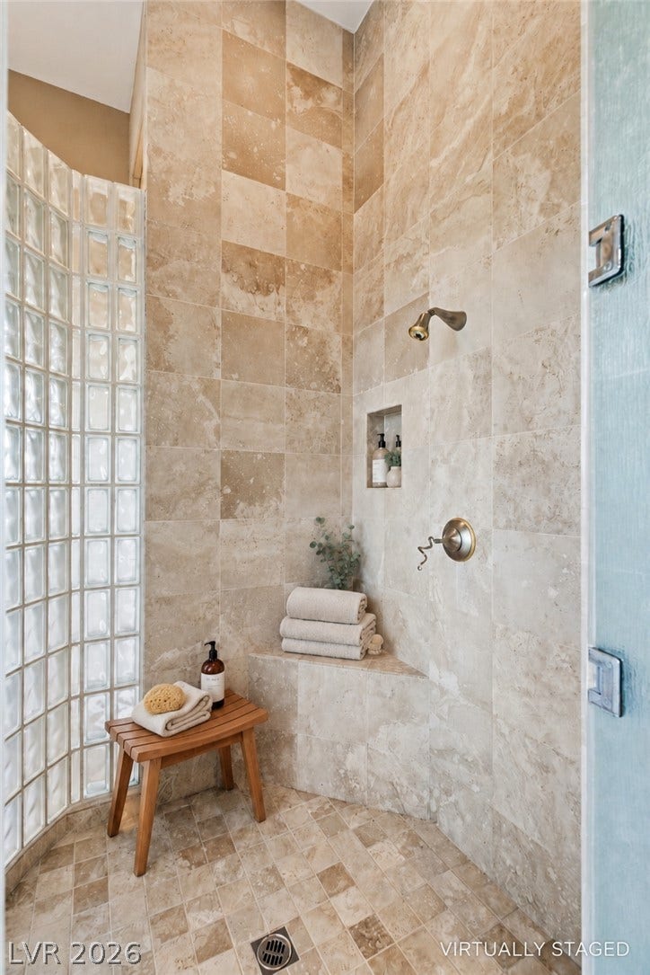 6 Brookridge Drive, Henderson, NV 89052 Floor-to-ceiling stone tile and a curved glass block wall define this walk-in shower.