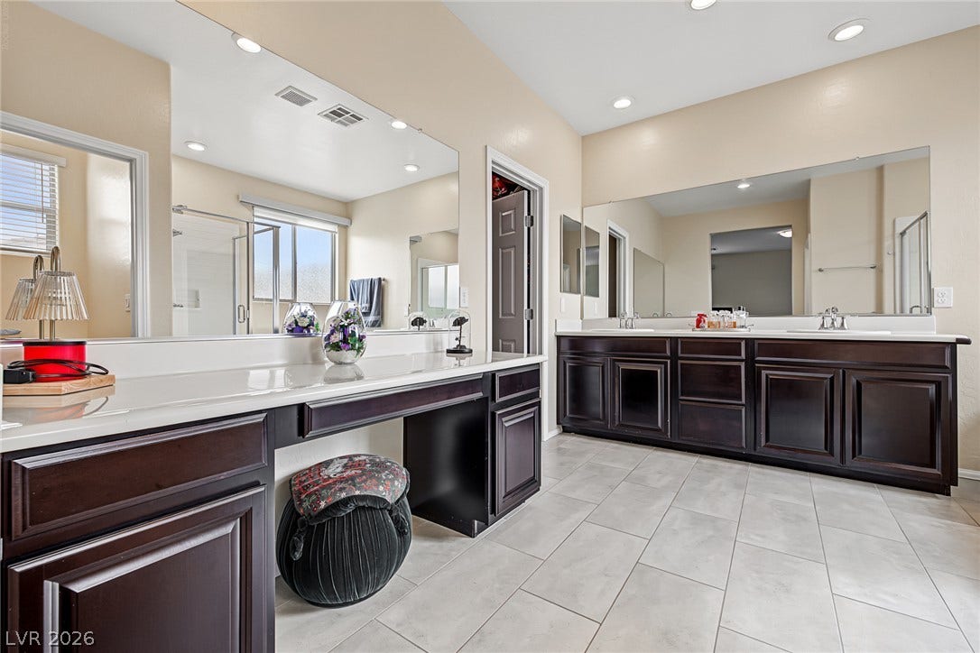3813 Birch River Street, North Las Vegas, NV 89032 Rich dark wood cabinetry pairs beautifully with light tile flooring in this expansive primary bath.