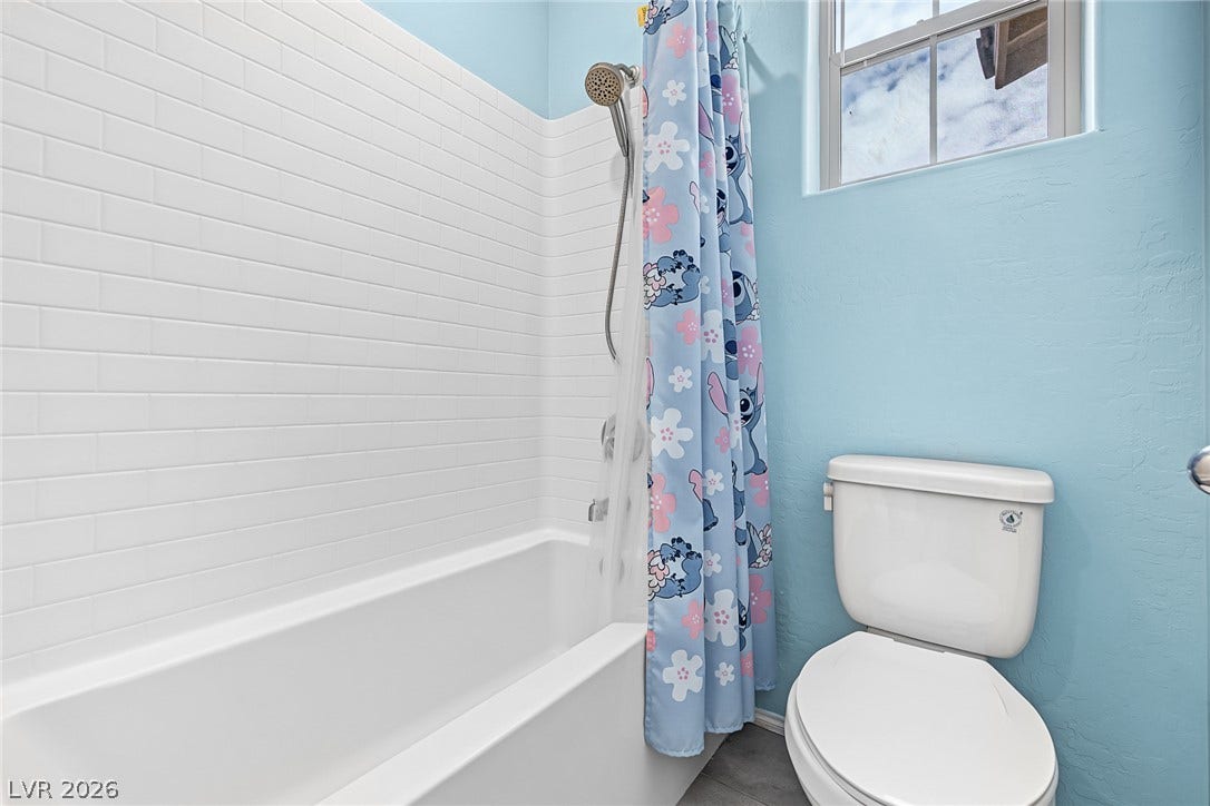 3813 Birch River Street, North Las Vegas, NV 89032 Crisp subway tile surrounds the built-in tub in this bright secondary bathroom.