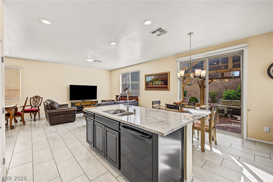 3813 Birch River Street, North Las Vegas, NV 89032 An open floorplan seamlessly connects the stone-countertop kitchen island with adjacent dining and living areas.