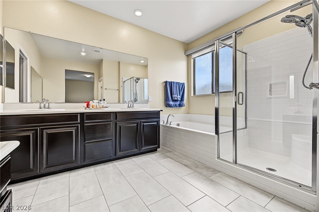 3813 Birch River Street, North Las Vegas, NV 89032 Tiled flooring and a separate glass-enclosed shower elevate this spacious bathroom.
