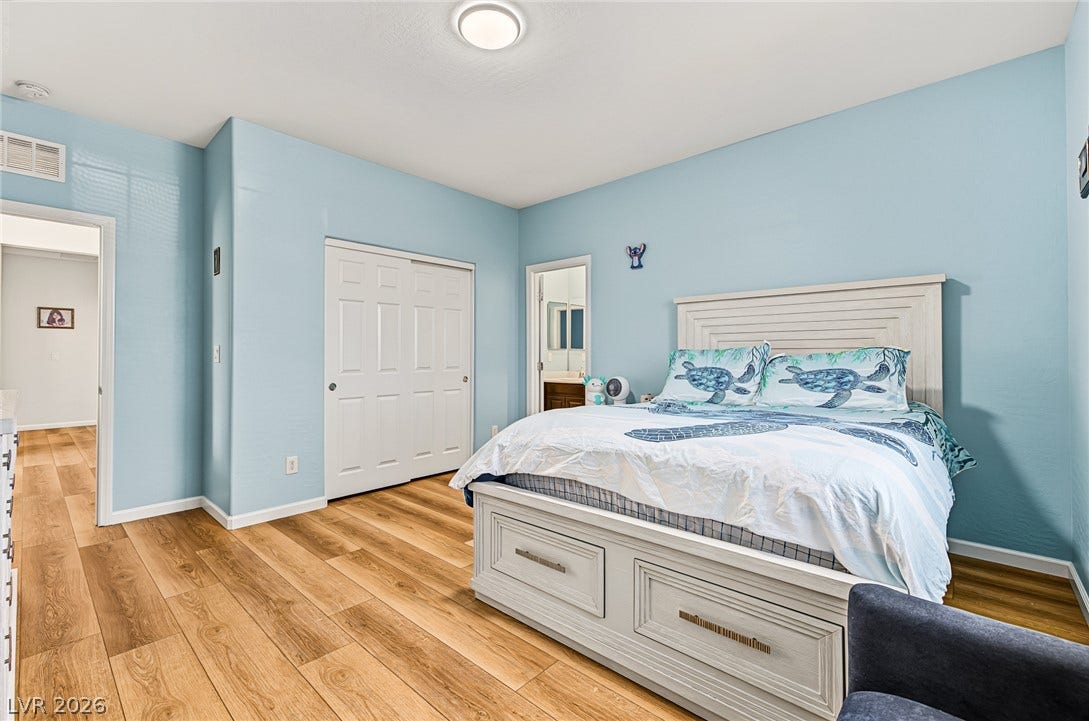 3813 Birch River Street, North Las Vegas, NV 89032 Rich wood-look flooring and smooth plaster walls define this comfortable bedroom space.