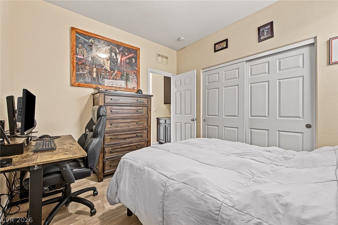 3813 Birch River Street, North Las Vegas, NV 89032 A comfortable bedroom setup featuring smooth wood flooring and integrated closet space.