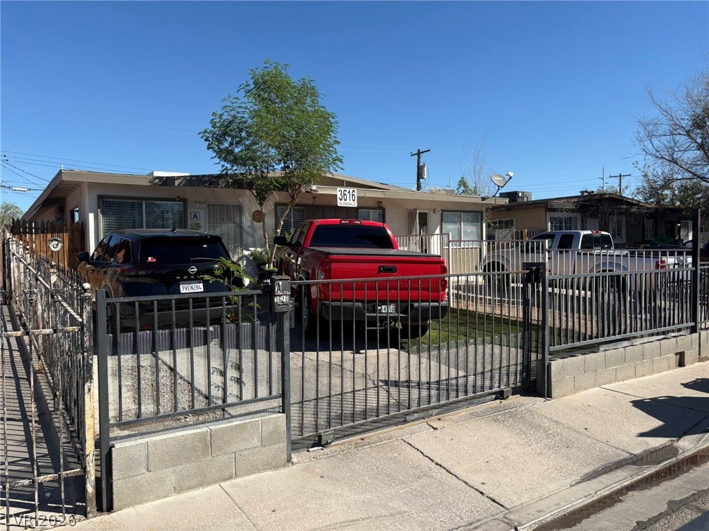 Secure gated entry and a paved front driveway lead to this single-story residential structure.