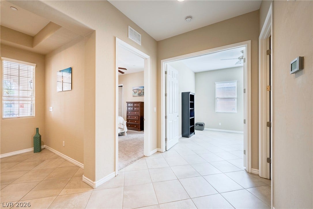 Tiled flooring and neutral walls guide transition spaces into adjoining rooms.