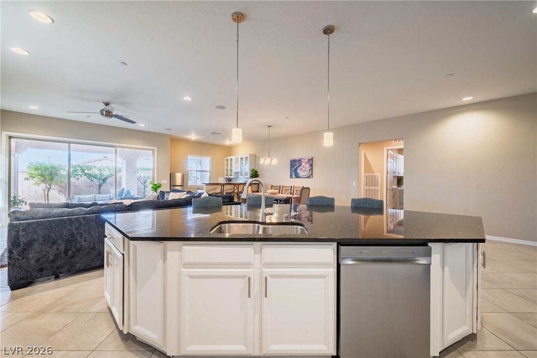 Gleaming stone countertops and ceramic tile flooring define this spacious open kitchen and living area.