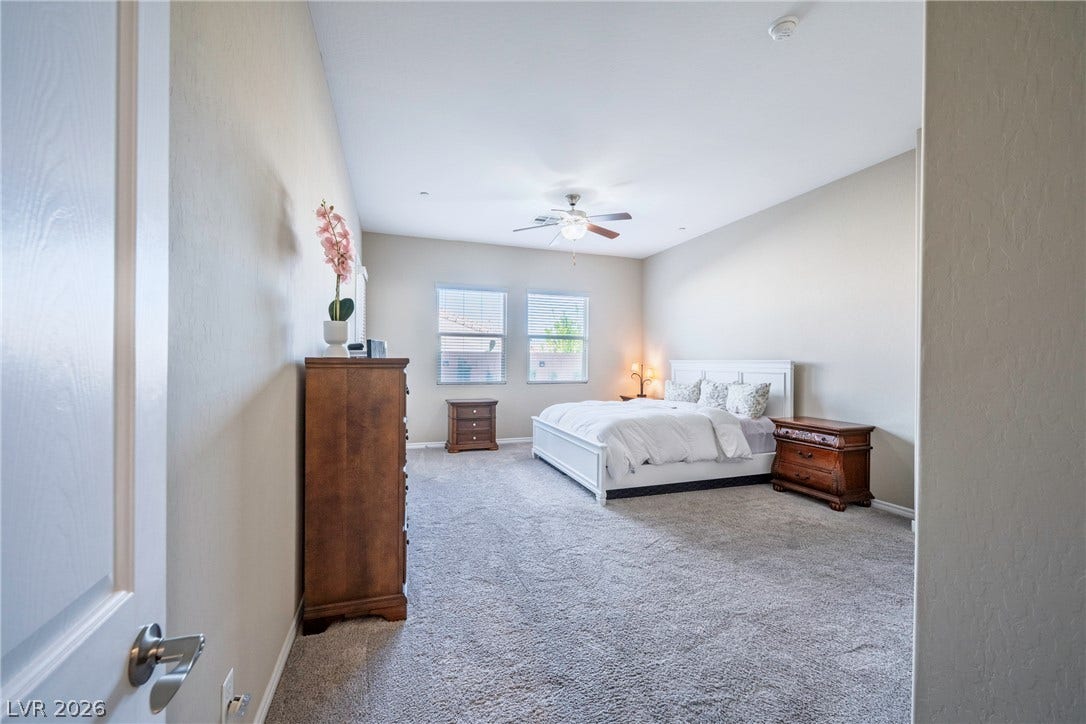 Plush carpeting and dual windows enhance this serene bedroom retreat.