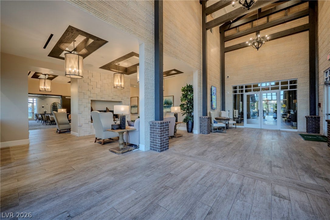 Dramatic timber beams and textured walls highlight a grand entrance foyer with wood-look flooring.