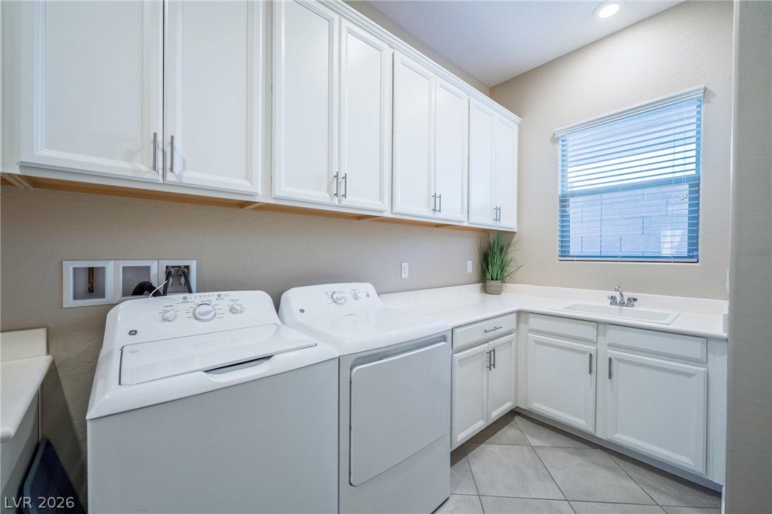 Ample cabinetry and a built-in sink optimize storage and functionality in this utility space.