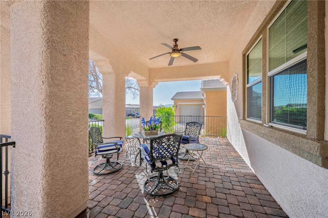 Shaded outdoor living is enhanced by durable brick pavers and structured stucco pillars.
