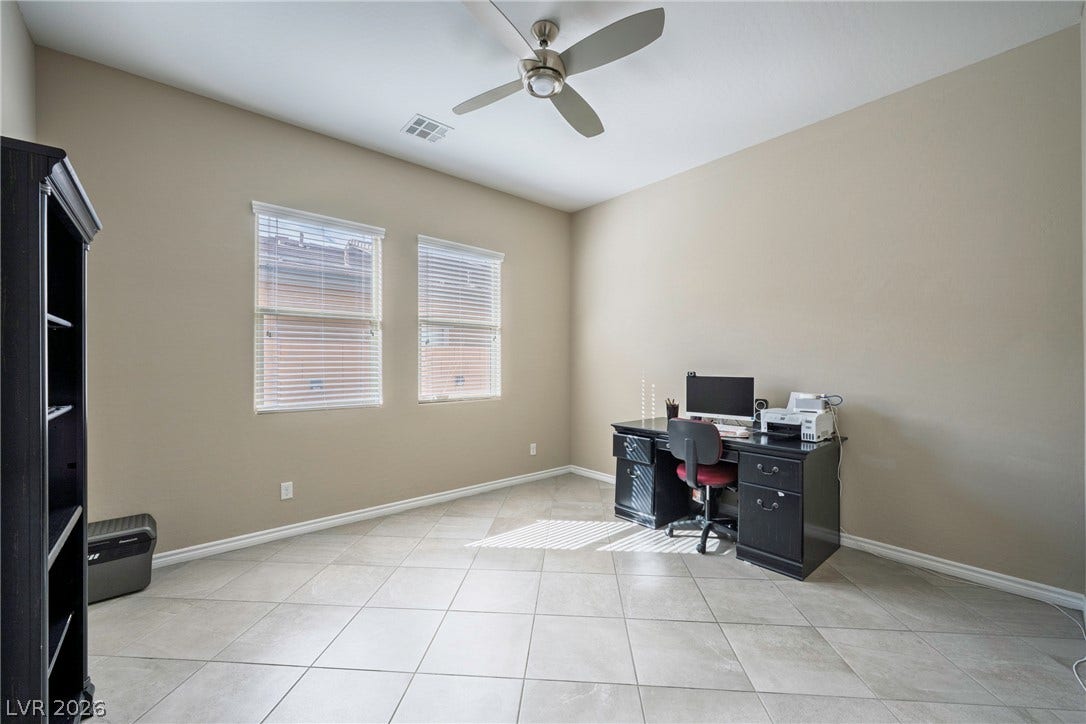Large tile flooring and tall windows create an ideal quiet home office environment.