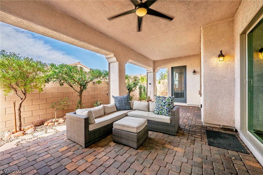 A spacious covered patio with brick pavers connects seamlessly to the private backyard.