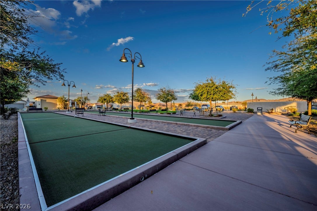 A beautifully landscaped neighborhood recreation area features outdoor courts under a clear blue sky.