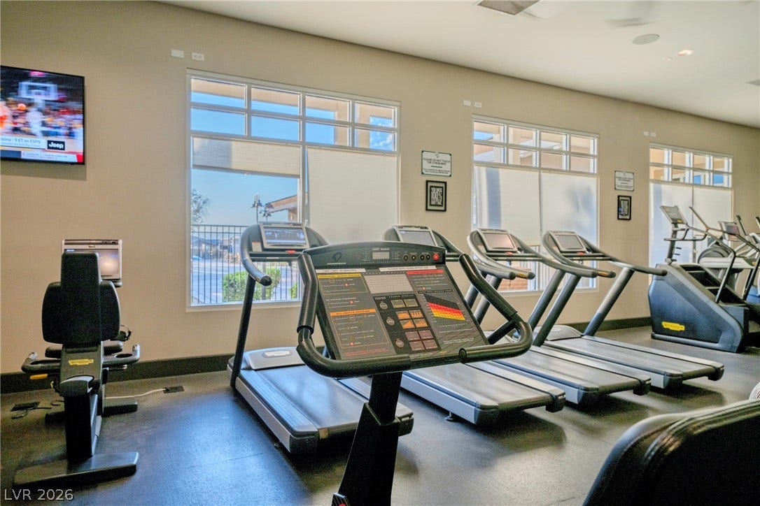 High ceilings and tall windows bring natural light into this dedicated workout space.