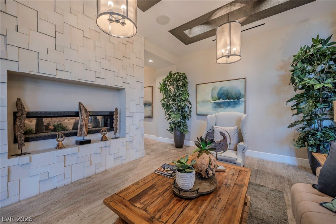 Exquisite wood ceiling details and a textured modern fireplace frame this welcoming living space.