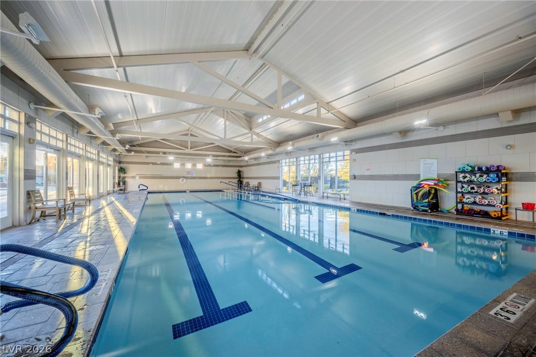 A spacious indoor pool is housed under soaring vaulted ceilings with exposed support trusses.