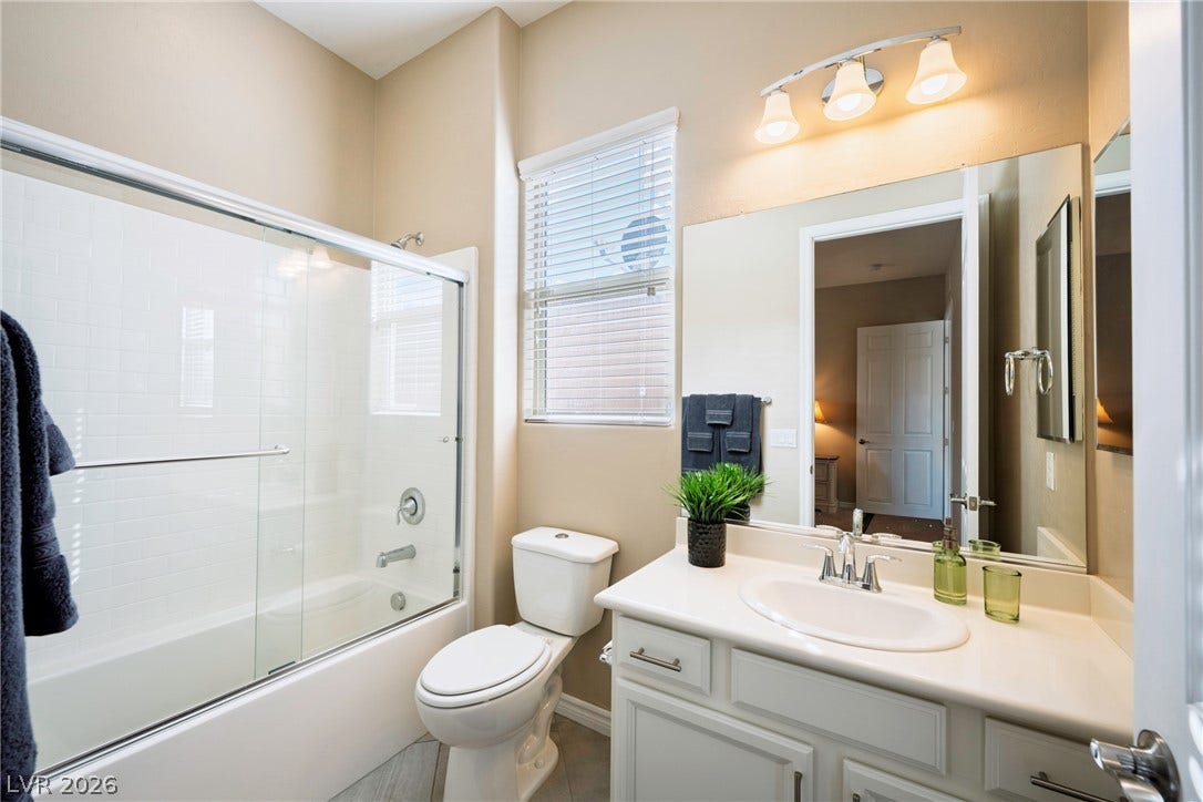 High ceilings and a glass-enclosed tub elevate this bathroom design.