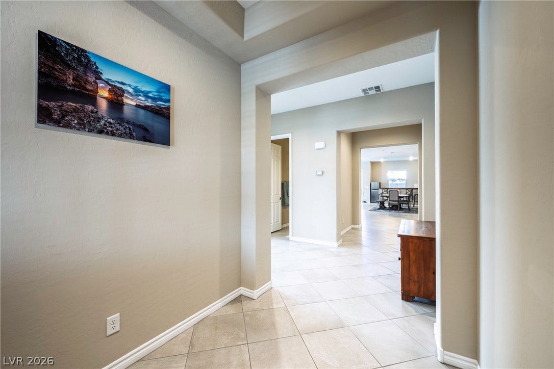 Clean tile flooring and a tray ceiling define this welcoming entry hallway.
