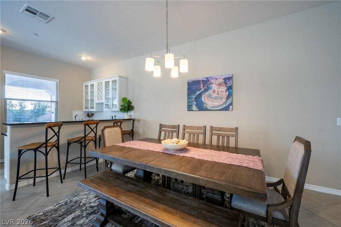 An inviting dining area flows into an open kitchen with raised counter seating.