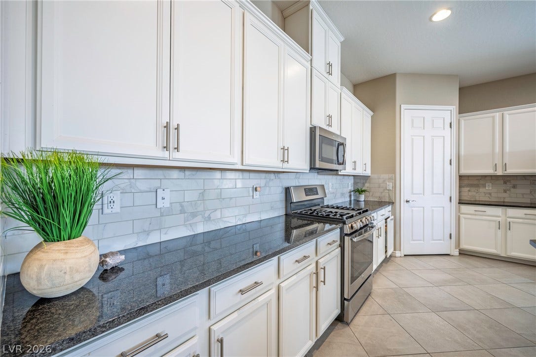 Polished granite countertops and classic tile flooring define this bright, functional kitchen space.