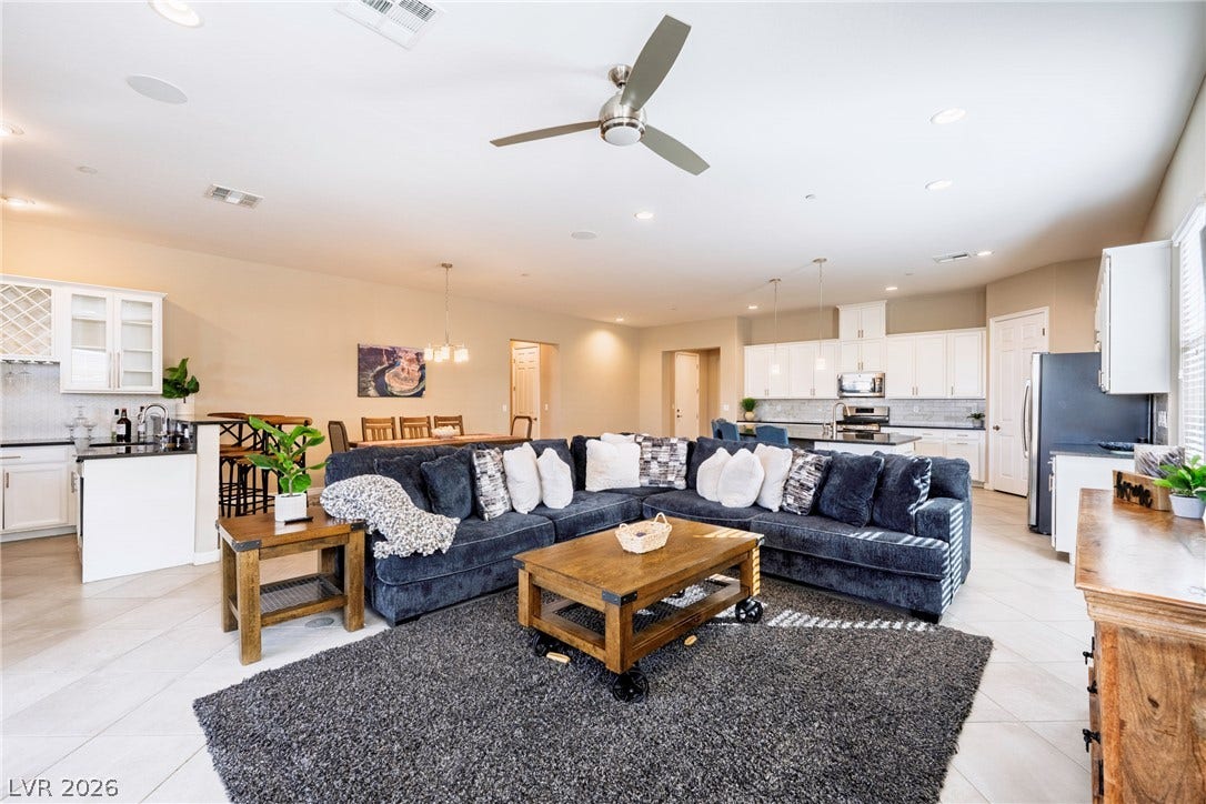 An open floorplan seamlessly connects the central living area with the kitchen and dining spaces.