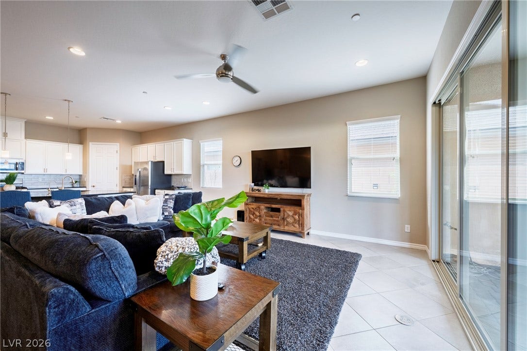 Sliding glass doors open from the tiled living space directly to the exterior.