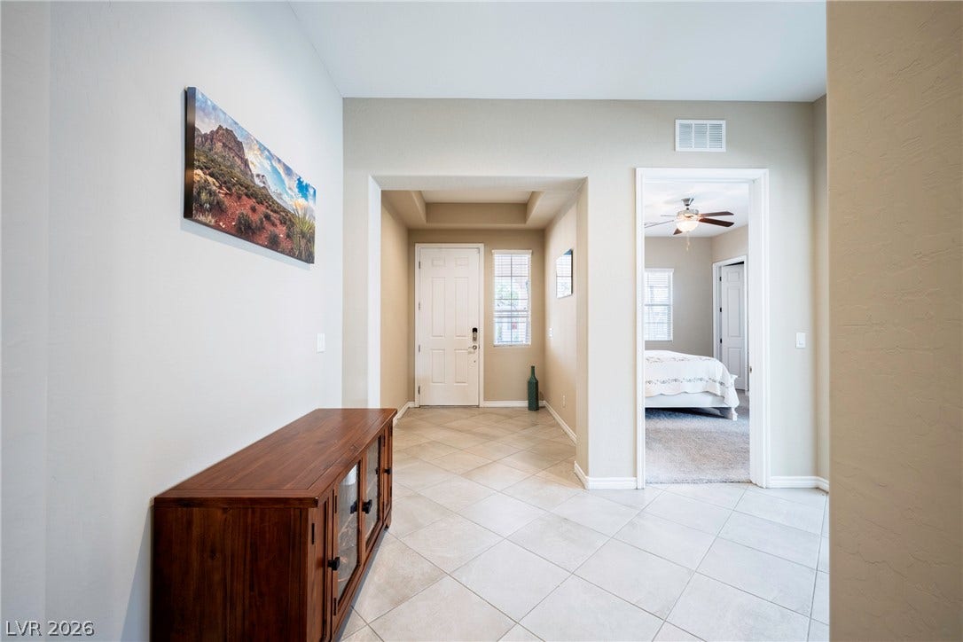 Tiled flooring and a recessed ceiling alcove define this welcoming entrance foyer.