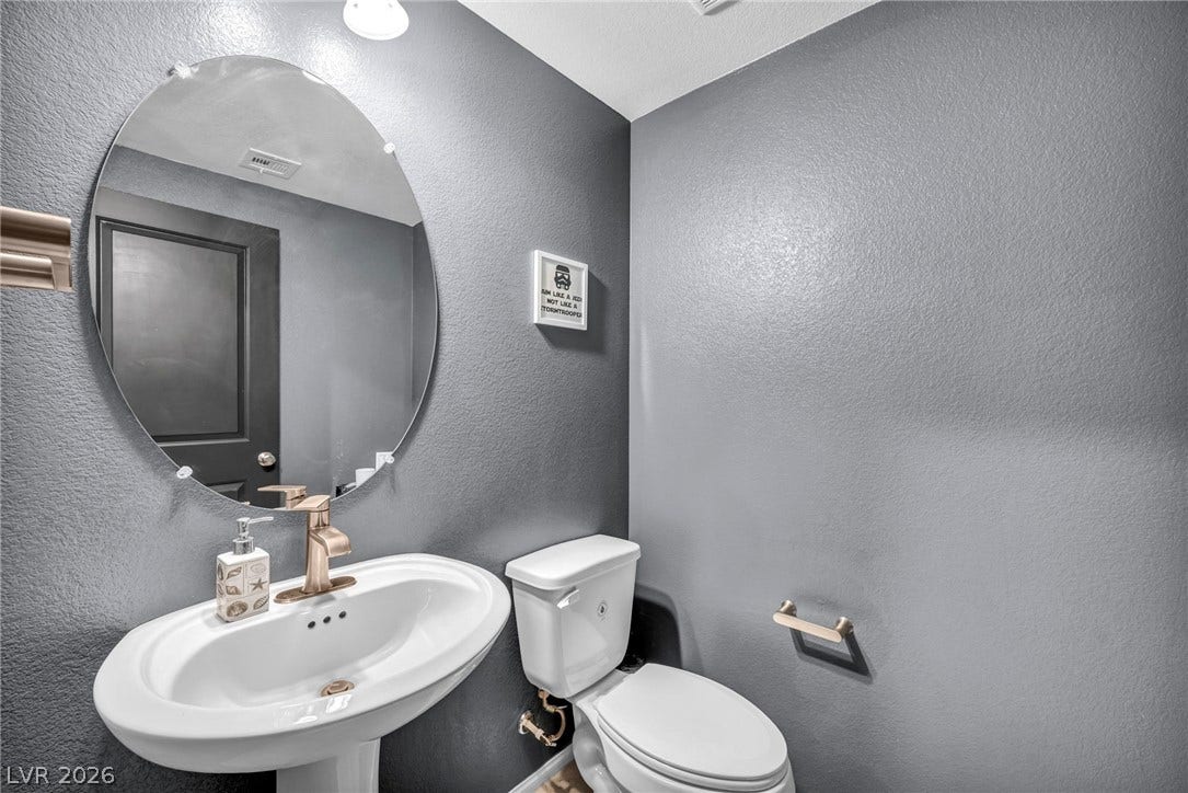 1205 Deep Valley Avenue, North Las Vegas, NV 89084 Modern fixtures and an elegant oval mirror define this stylish powder room.