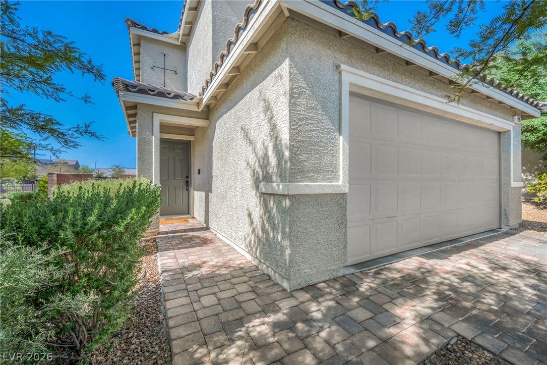 1205 Deep Valley Avenue, North Las Vegas, NV 89084 A paved brick path leads past the attached garage toward the private front entrance.