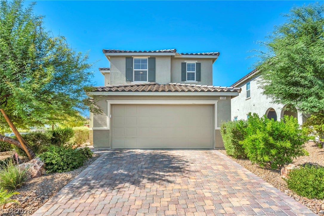 1205 Deep Valley Avenue, North Las Vegas, NV 89084 A paved driveway leads to the attached garage of this two-story stucco residence.