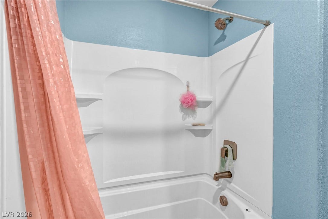 1205 Deep Valley Avenue, North Las Vegas, NV 89084 A classic tub and shower combination features molded shelving and bronze hardware.