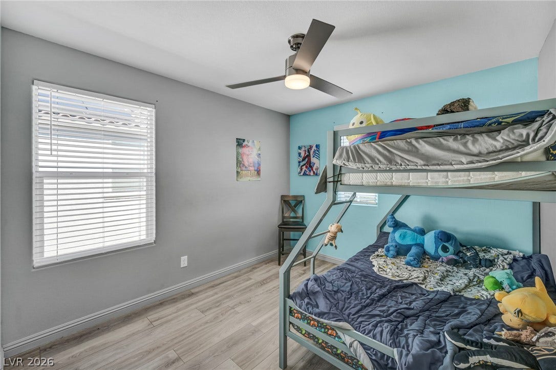 1205 Deep Valley Avenue, North Las Vegas, NV 89084 Smooth wood-look flooring and a wide window create a comfortable secondary bedroom space.